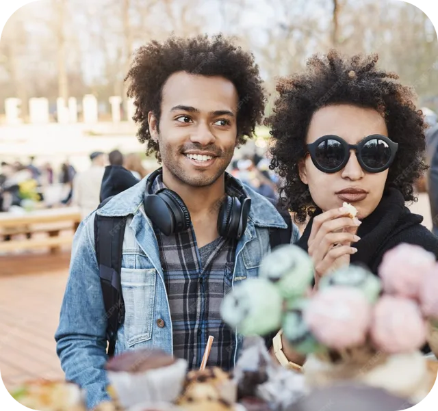 Two friends at an outdoor festival with treats